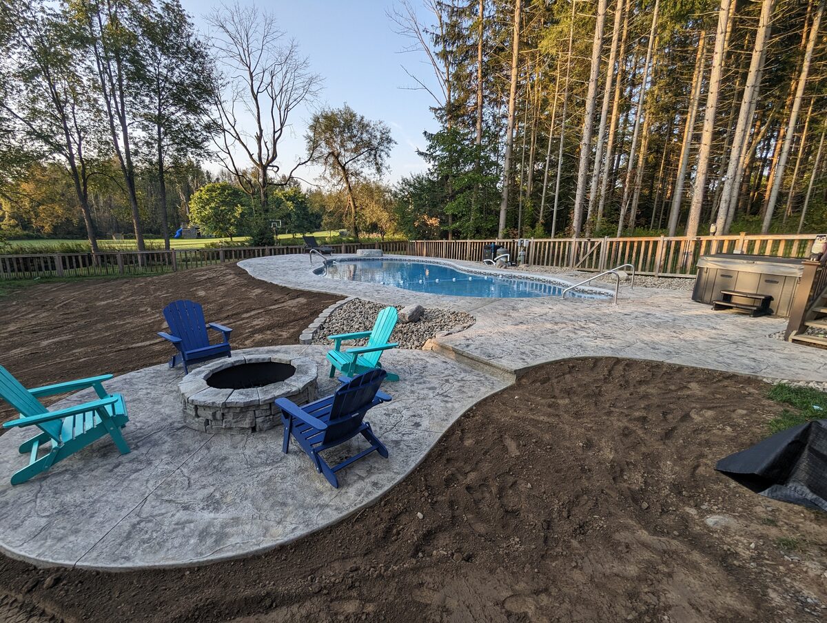 Stamped concrete patio with fire pit, pool and hot tub area in Syracuse NY