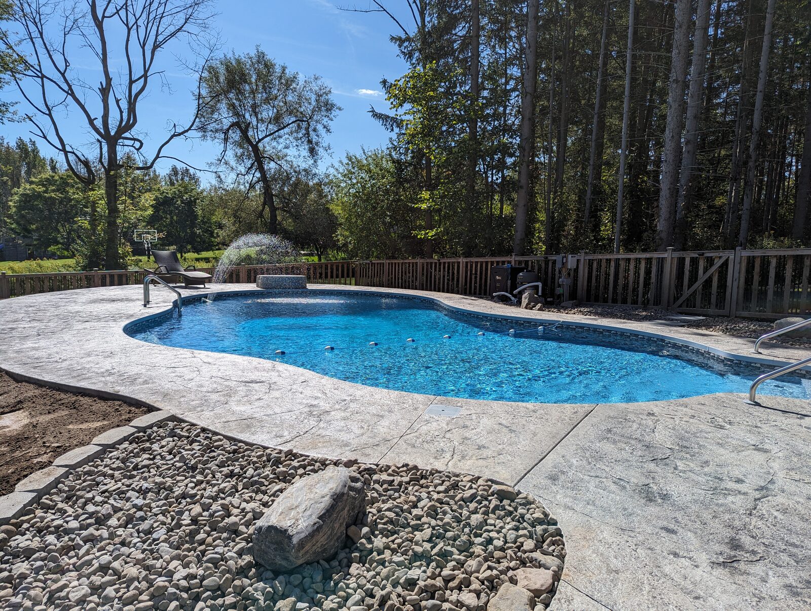 Stamped concrete pool deck with fountain feature completed in Syracuse NY